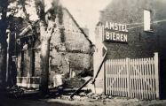 Panden die tijdens de granaatweken in 1944 zwaar werden beschadigd, De totaal vernielde textielwinkel van Doreleijers links van de poort. Voor meer details klik hier.