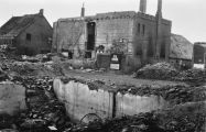 Panden die tijdens de granaatweken in 1944 zwaar werden beschadigd. In oktober 1944 werd het gemeentehuis door brand totaal vernield. Links staat het pand van slagerij van Rooij. Voor meer details klik hier.