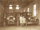 Kinderen Vugts in de garage bij 2 auto's die eind jaren 20 op de markt kwamen. De kentekens van de auto's zijn N-22505 en N-20272. Voor meer details klik hier.