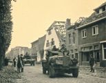 Legervoertuigen van de geallieerden in de Hoofdstraat in oktober 1944 met veel beschadigde panden zoals het gemeentehuis. Voor meer details klik [/ hier.]