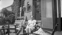 Man en vrouw op een bankje op het terras bij Huize Nieuwegaard. Voor meer details klik hier.