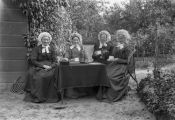 Vier dames in de tuin van Huize Nieuwegaard. Voor meer details klik hier.