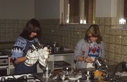 Twee leerlingen aan de afwas op de huishoudschool. Voor meer details klik [/ hier.]