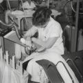 Productie van kousen in de fabriek van Jansen de Wit. Het afzuigen van draadjes na het kettelen. Voor meer details klik hier.
