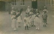 De Mariaschool Pastoor van Erpstraat 4. Kinderen op de speelplaats, verkleed, palmtakken. Op de achtergrond de kleuterschool. Voor meer details klik hier.